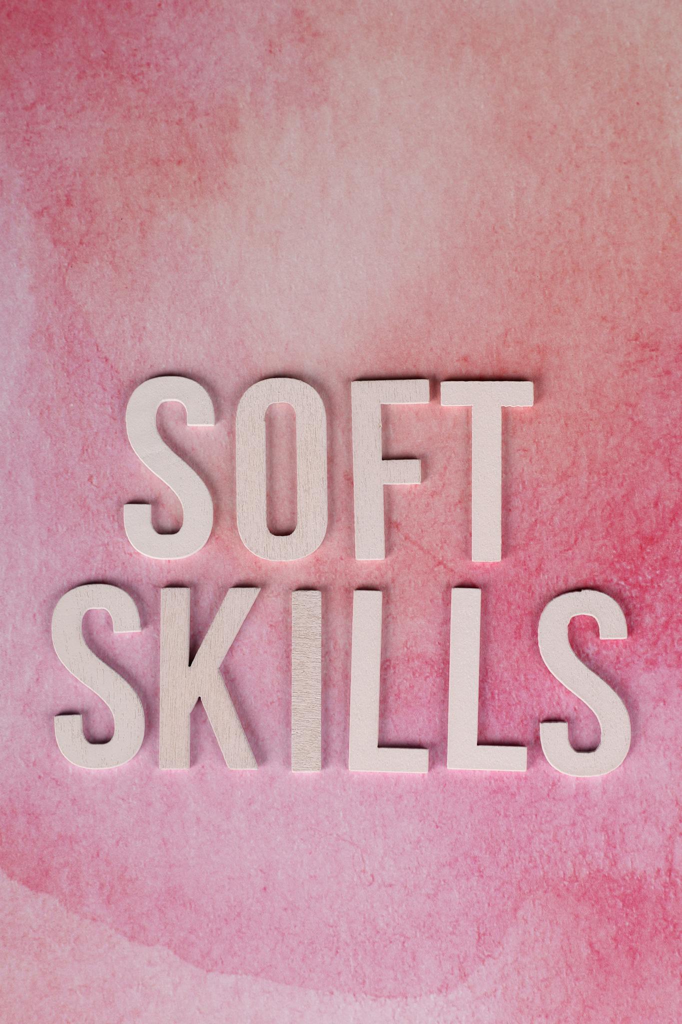 Conceptual image of soft skills typography on a pink watercolor background.